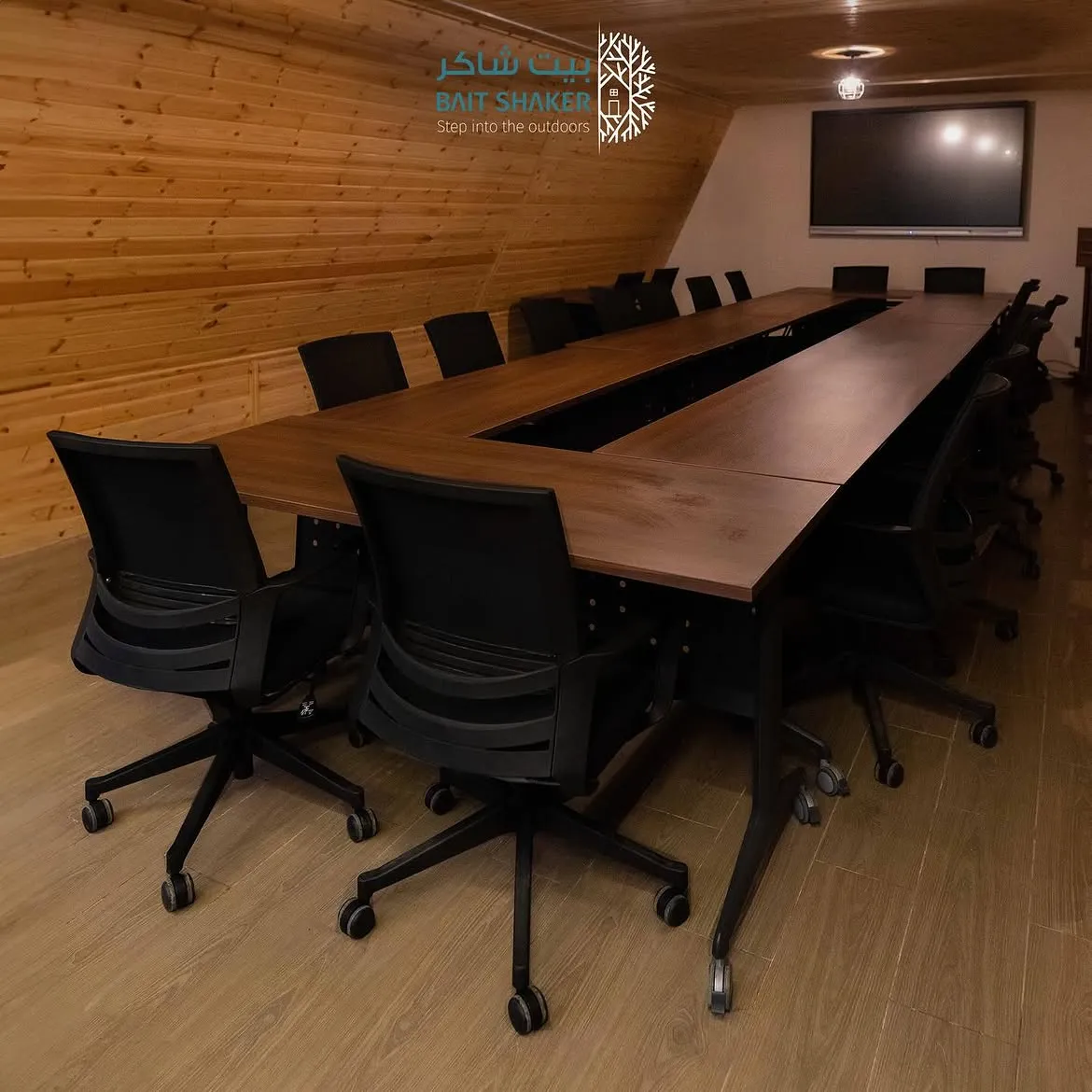An indoor meeting room with a boardroom table and presentation screen at Bait Shaker