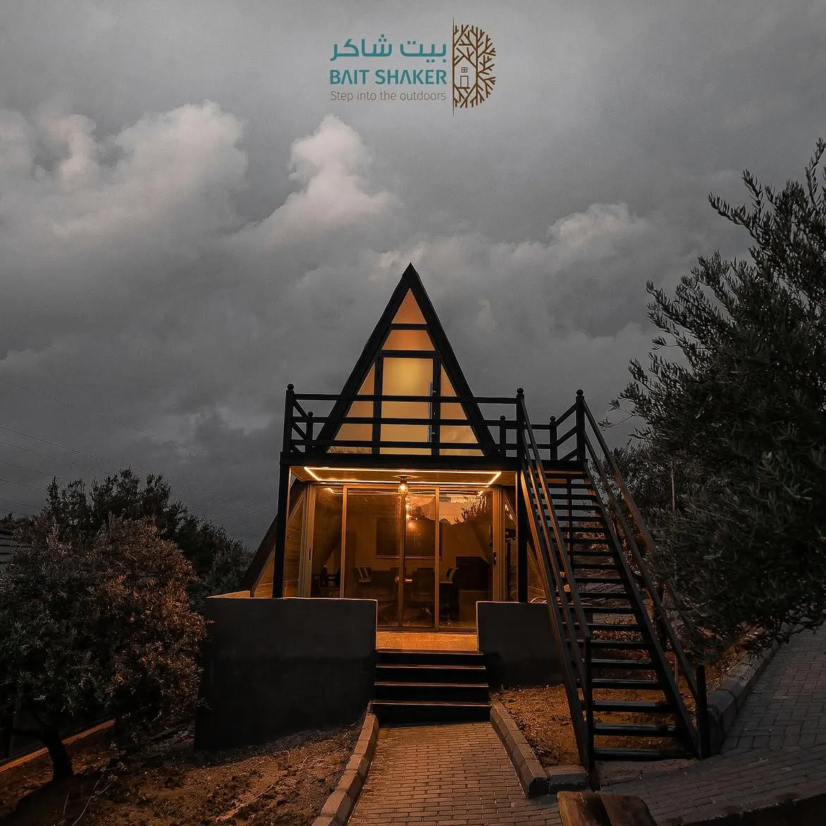 The illuminated A-frame tree house at Bait Shaker at dusk
