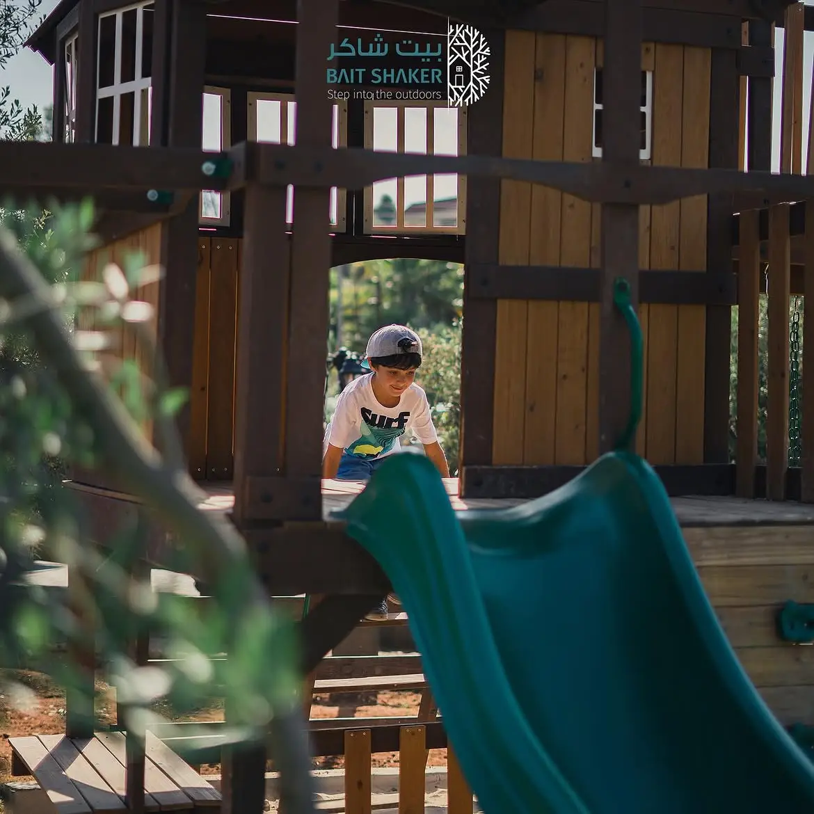 A child playing on the wooden play fort at Bait Shaker's kids' play area
